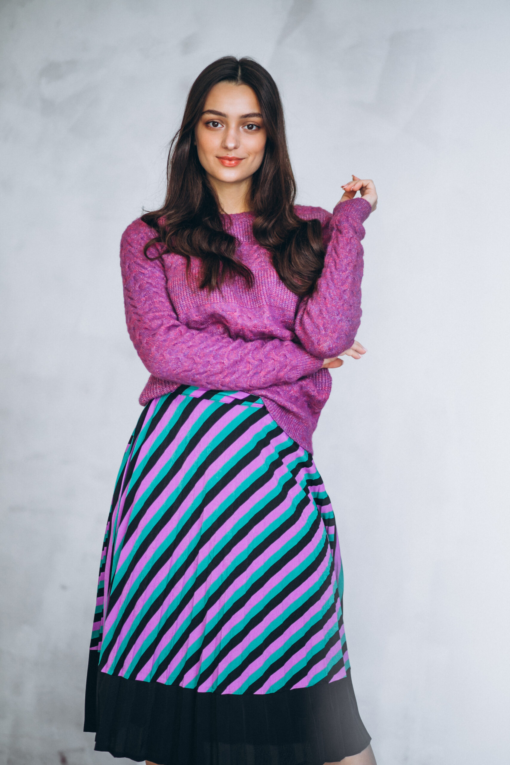 beautiful woman in a purple sweater and skirt in studio